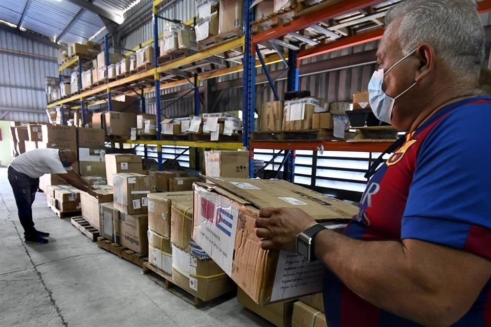 Trabajadores acomodan insumos sanitarios donados por China a Cuba.