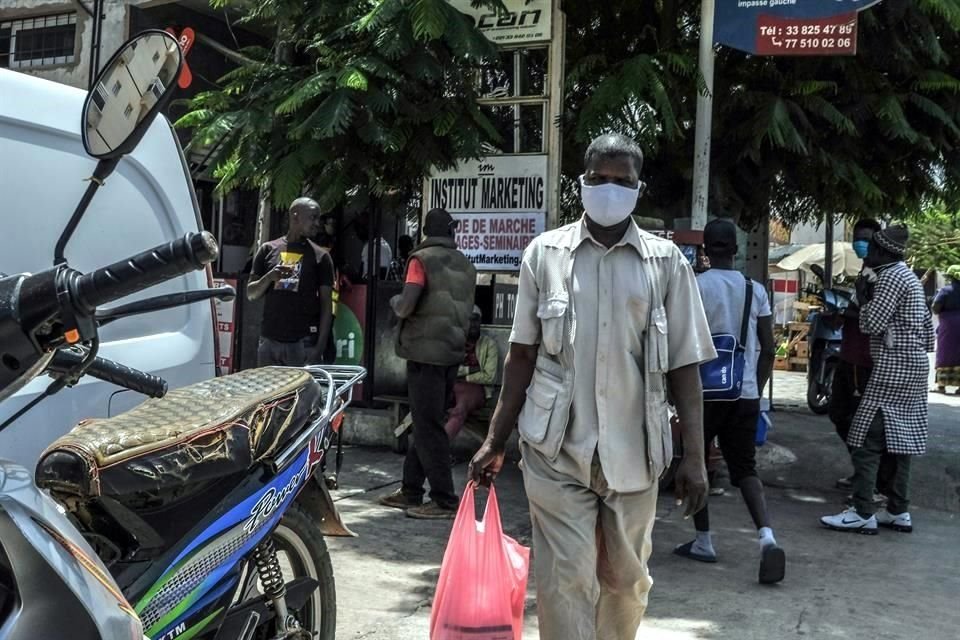 Un hombre portando una mascarilla mientras camina en una calle en Dakar, Senegal.