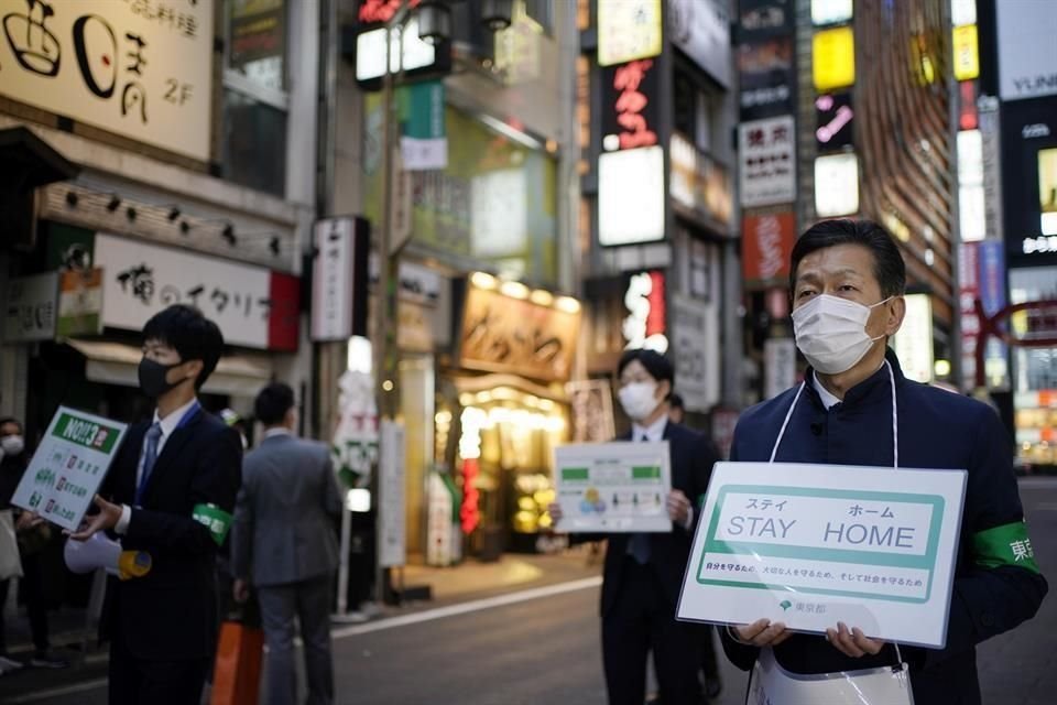 Trabajadores del Gobierno metropolitano de Tokio con pancartas de 'Quédate en casa'.