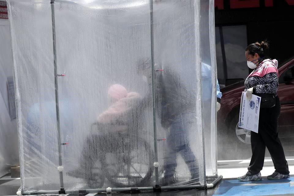 Personas entran a través de un túnel desinfectante en el Hospital del Seguro Social Quito Sur, en la capital de Ecuador.