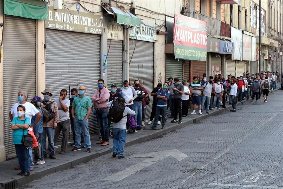 Una fila de mas de cien personas en el centro de la CDMX el primer día del decreto de la Fase 3 de la pandemia por Covid-19.