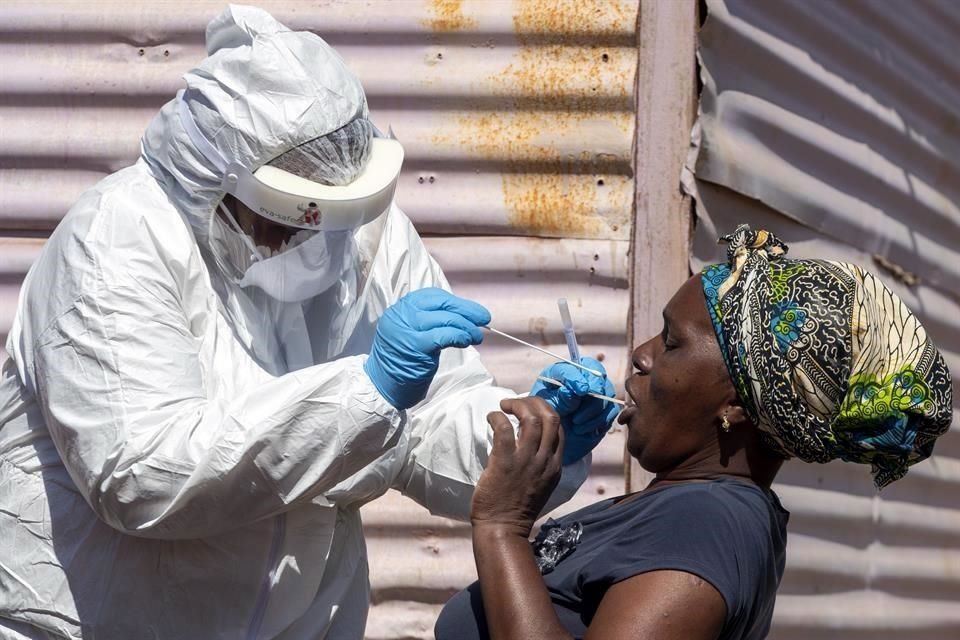 Un trabajador sanitario recolecta muestras a una mujer para realizar una prueba de Covid-19, en Johanerburgo, Sudáfrica.