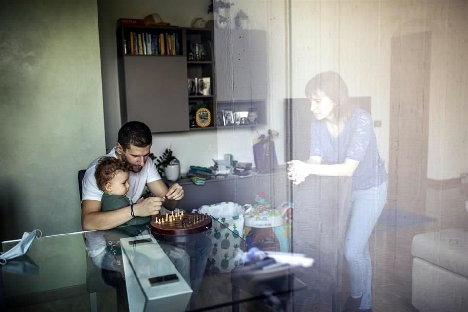 EnBergamo, Italia, Federica Brena mira a su esposo y su bebé a través de una ventana, tras tener que aislarse en la misma casa por Covid-19.