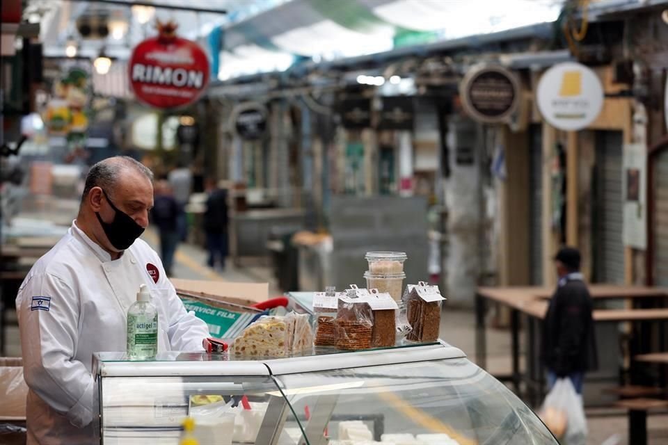 Un vendedor porta un cubrebocas en el mercado principal de Jerusalén, tras la reactivación gradual del comercio.