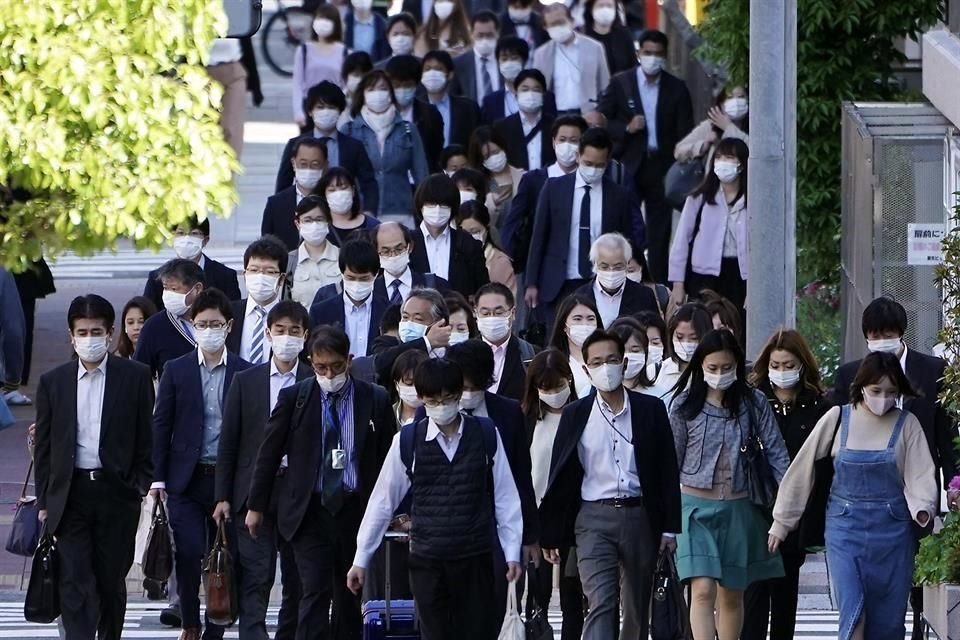 Personas usando máscras en hora pico por las calles de Tokio.