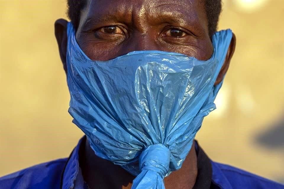 Un hombre en Sudáfrica usa una bolsa de plástico como mascarilla para protegerse del Covid-19.