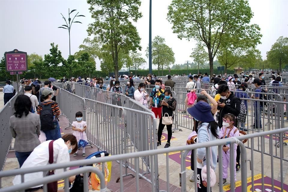 Visitantes usan cubrebocas en la entrada de Disneyland.