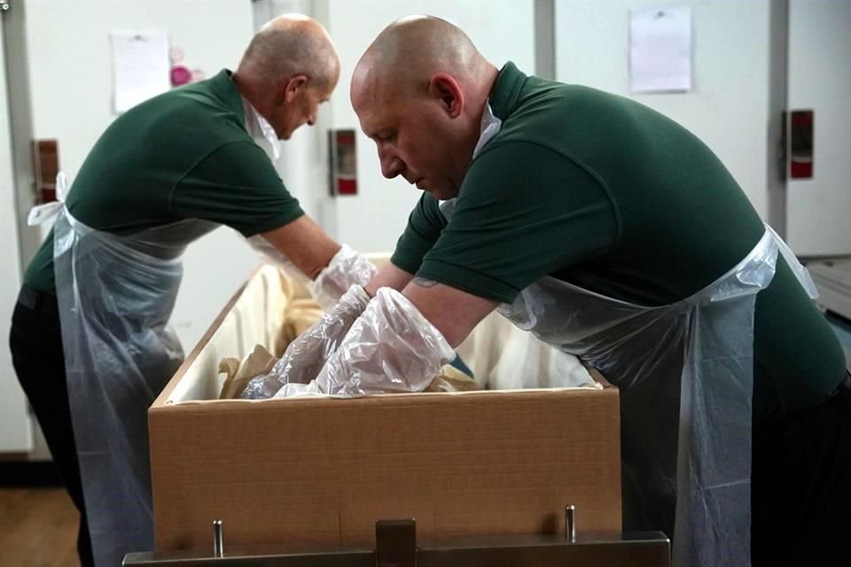 Trabajadores embalsaman un cuerpo en el cementerio de Lambeth, en Londres, Inglaterra.