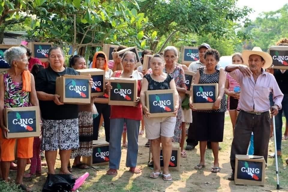 Los habitantes, en su mayoría mujeres, posaron con sus despensas ante los hombres armados.