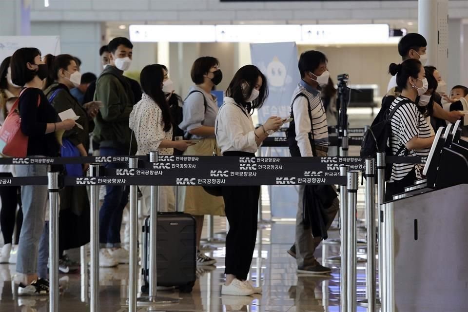 pasajeros hacen fila en aeropuerto de Gimpo en Seúl.