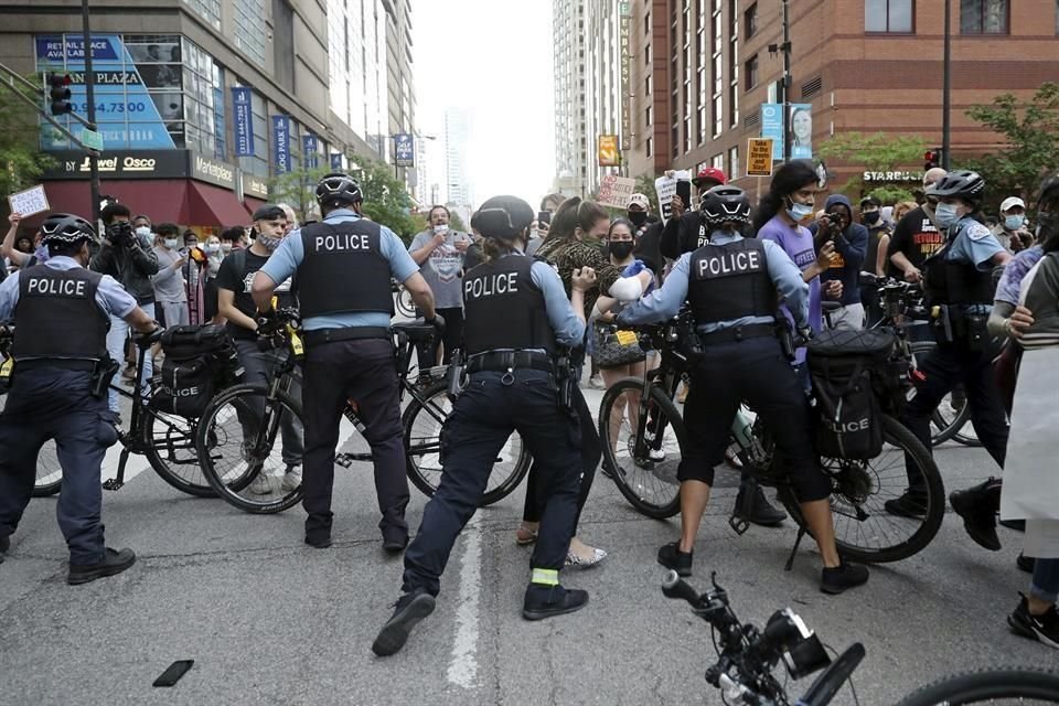 Manifestantes en una marcha intentaban romper un bloqueo policial el viernes en Minneapolis.