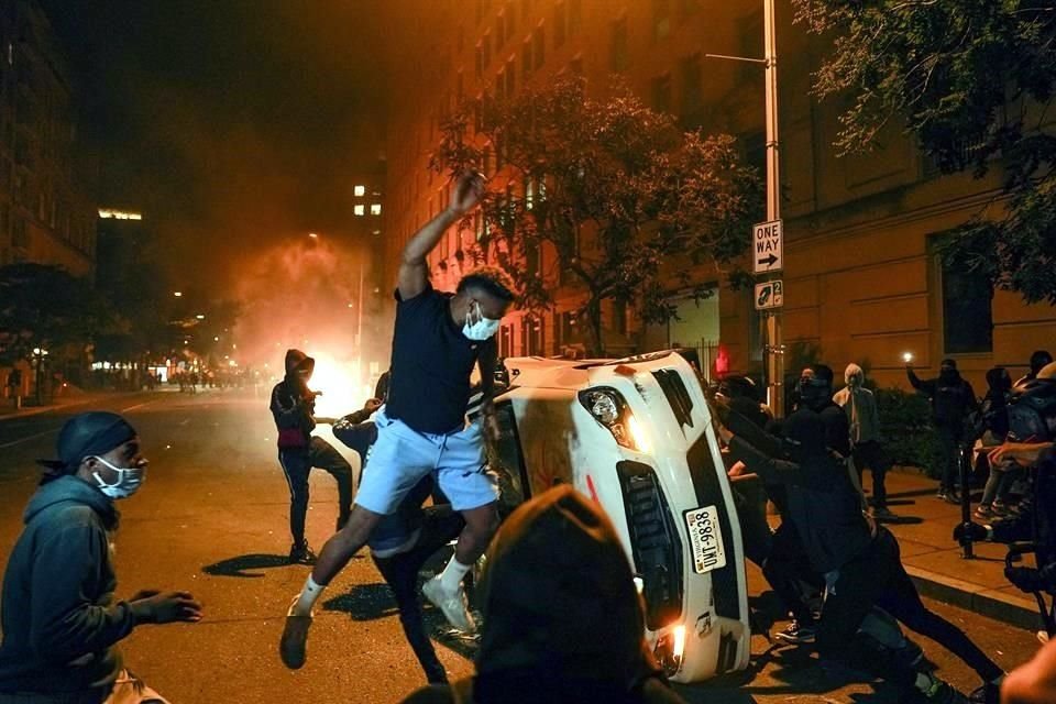 Manifestantes indignados por la muerte de George Floyd destruyen un auto cerca de la Casa Blanca.