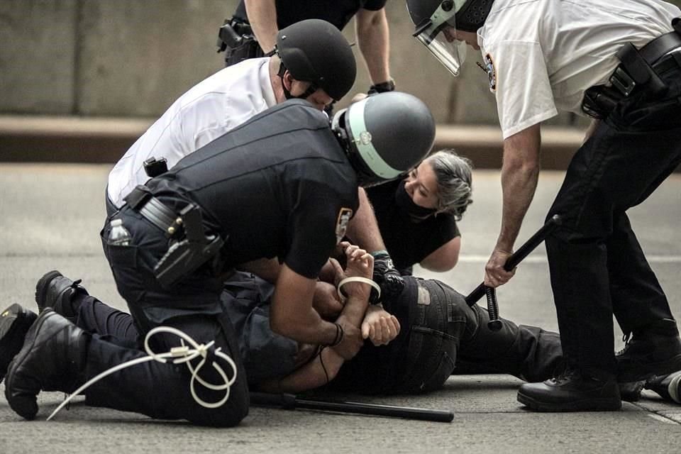 Policías arrestan a una persona que se resiste a dejar las calles durante marcha pacífica en Nueva York.