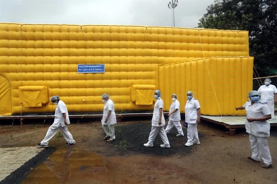 Enfermeros del Hospital Tata en Mumbai, India, caminan a lado de una instalación temportal para para atender a personas con cáncer y Covid-19.