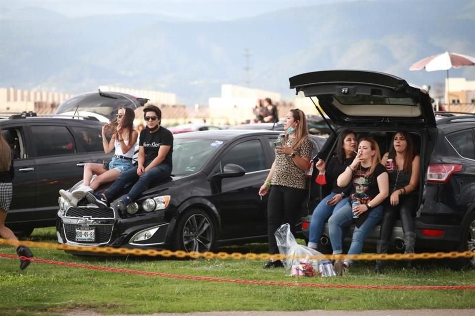Afuera de sus autos, los fans de la banda disfrutan del espectáculo.