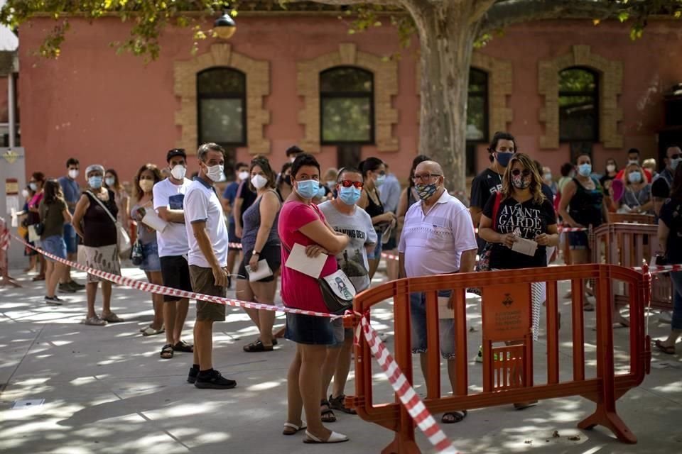 Personas hacen fila en Barcelona para realizarse pruebas de Covid-19.