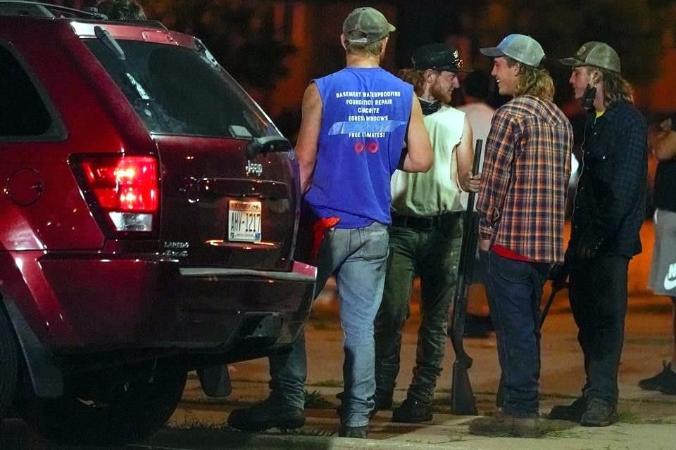 Un grupo de hombres con rifles hace 'guardia' en Kenosha, Wisconsin, durante las manifestaciones.