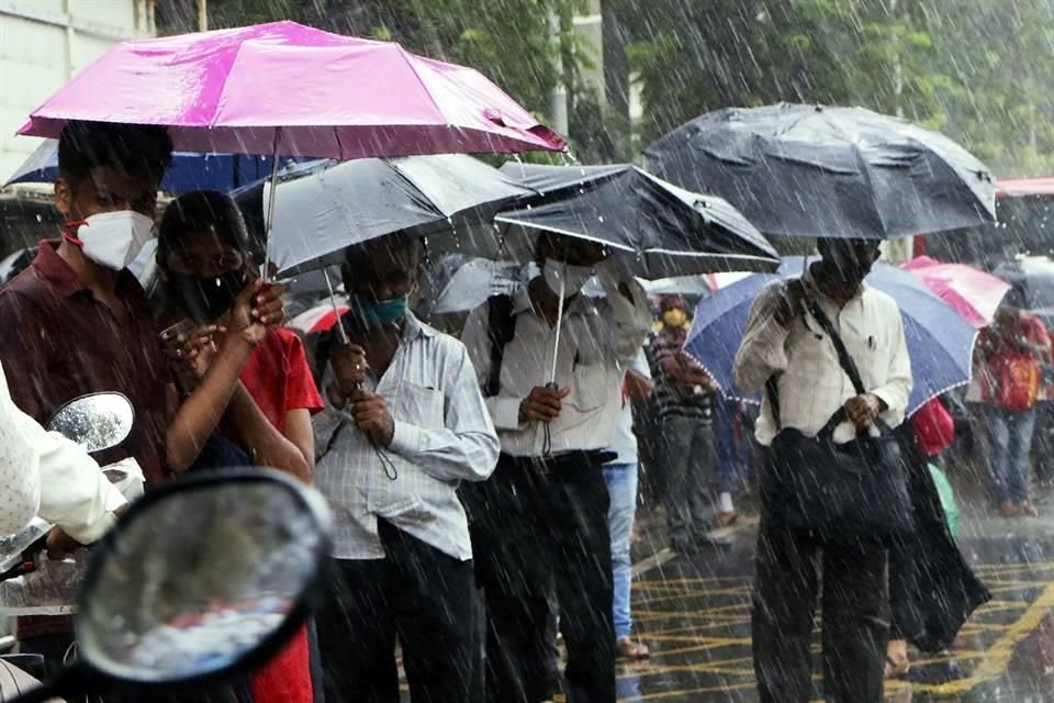 Personas esperan un autobús en Mumbai, India, país que ha relajado medidas para permitir la reapertura económica.