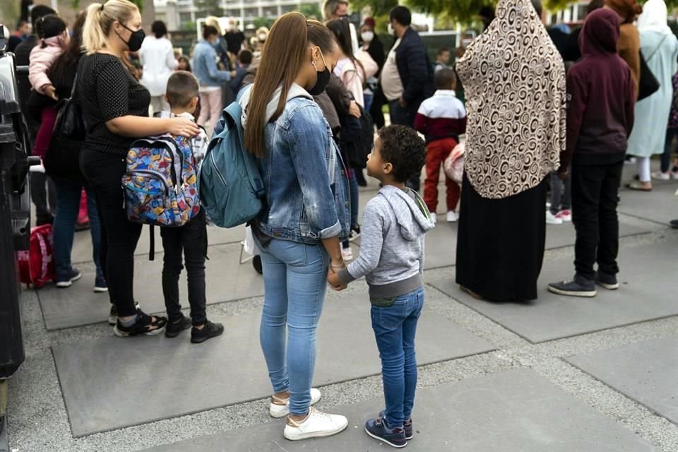 En Bruselas, Bélgica, donde también se reanudaron las clases, padres esperan junto a sus hijos afuera de la escuela.