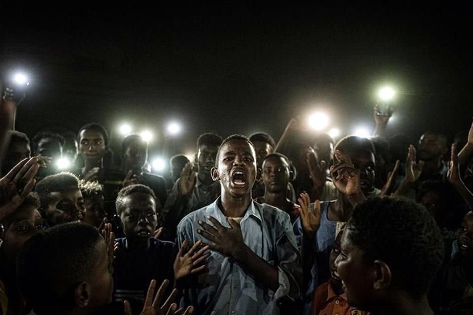 La imagen ganadora de este año, tomada por Yasuyoshi Chiba, muestra a un joven recitando un poema en medio de una protesta en Sudán.