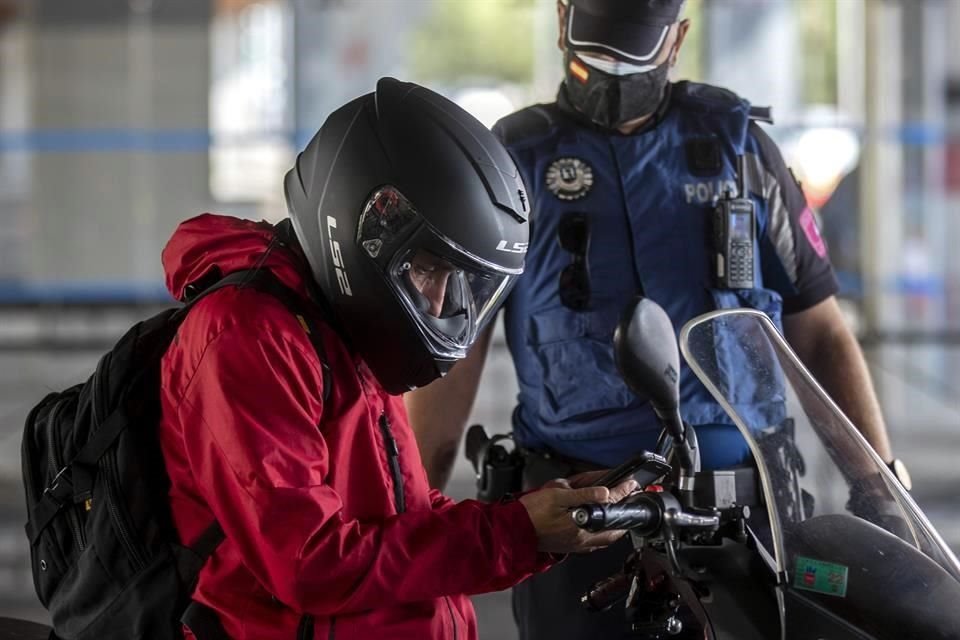 Un policía en Madrid realiza una revisión a un motociclista, en medio de la segunda ola de la pandemia.