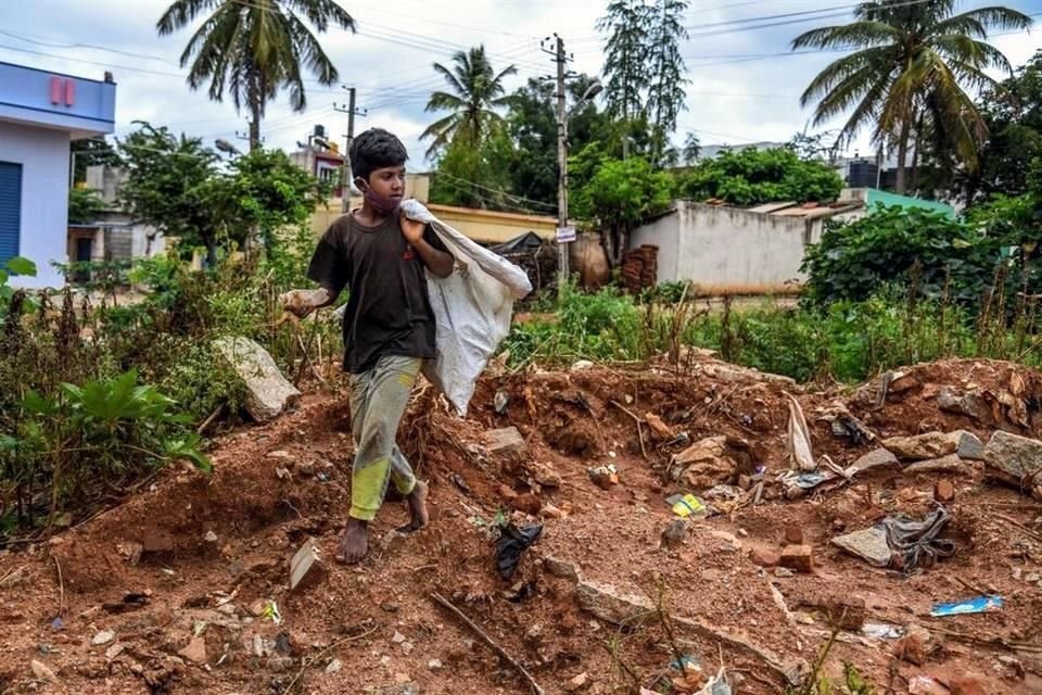 Rahul, de 11 años, recolecta plástico para venderlo a un reciclador en el sur de la India.