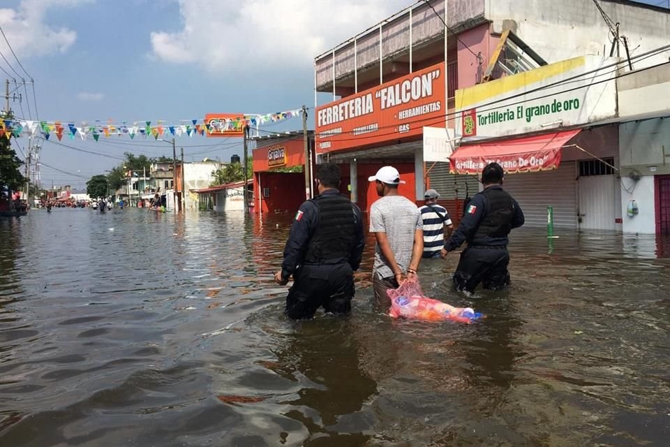 Autoridades y un lugareño contemplan la inudanción causada por el Río Grijalva.