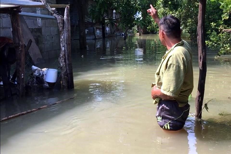 La población en este lugar vive afuera de sus casas, sobre la carretera, y el agua tiene ya más de una semana adentro de las casas.