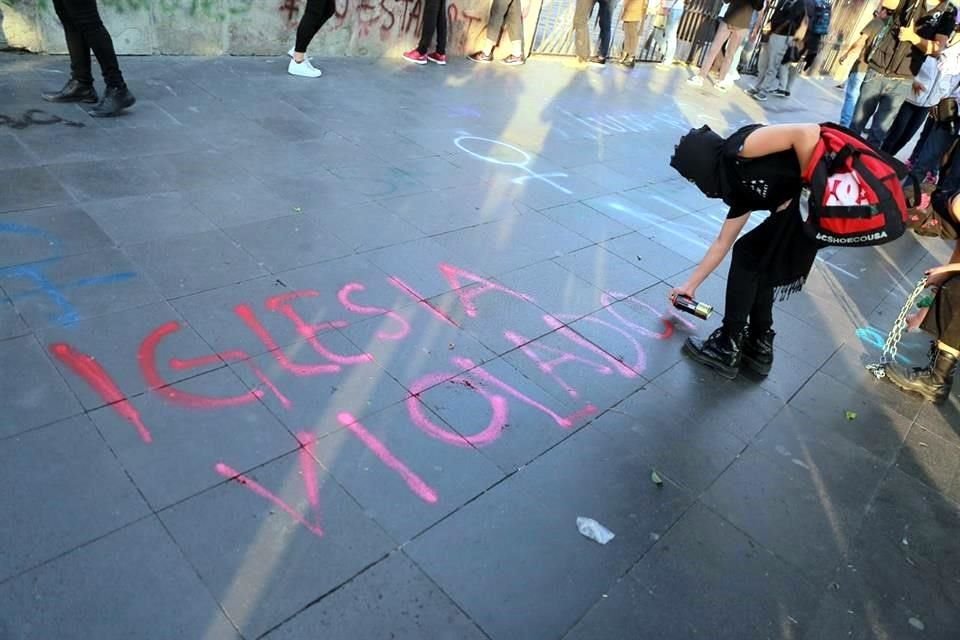 Luego de intentar saltar la barda de la Catedral, realizaron pintas en contra de la Iglesia.