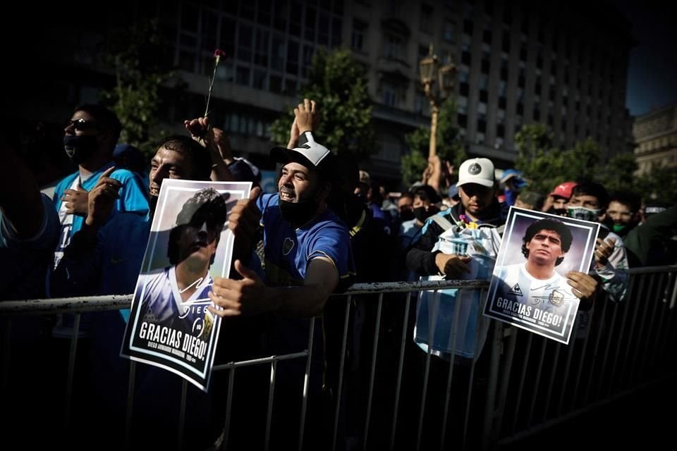 Con cánticos, flores, playera y lágrimas, la afición argentina se reúne, sin todas las medidas sanitarias, para despedir en la Casa Rosada a Diego Armando Maradona.