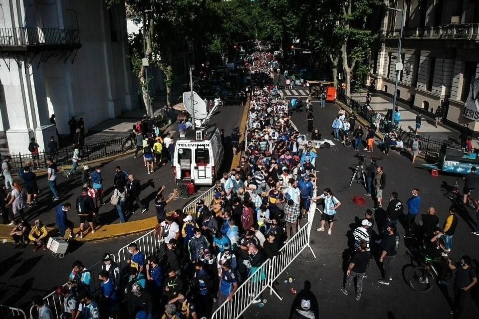 Con cánticos, flores, playera y lágrimas, la afición argentina se reúne, sin todas las medidas sanitarias, para despedir en la Casa Rosada a Diego Armando Maradona.