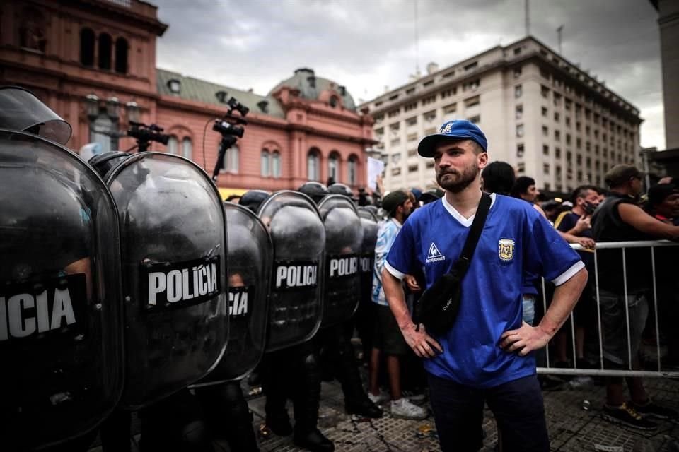 Con cánticos, flores, playera y lágrimas, la afición argentina se reúne, sin todas las medidas sanitarias, para despedir en la Casa Rosada a Diego Armando Maradona.