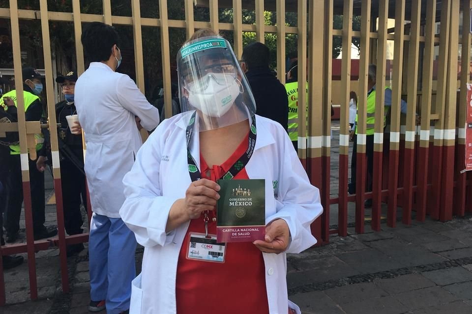 Una trabajadora de la salud muestra su cartilla de vacunación.