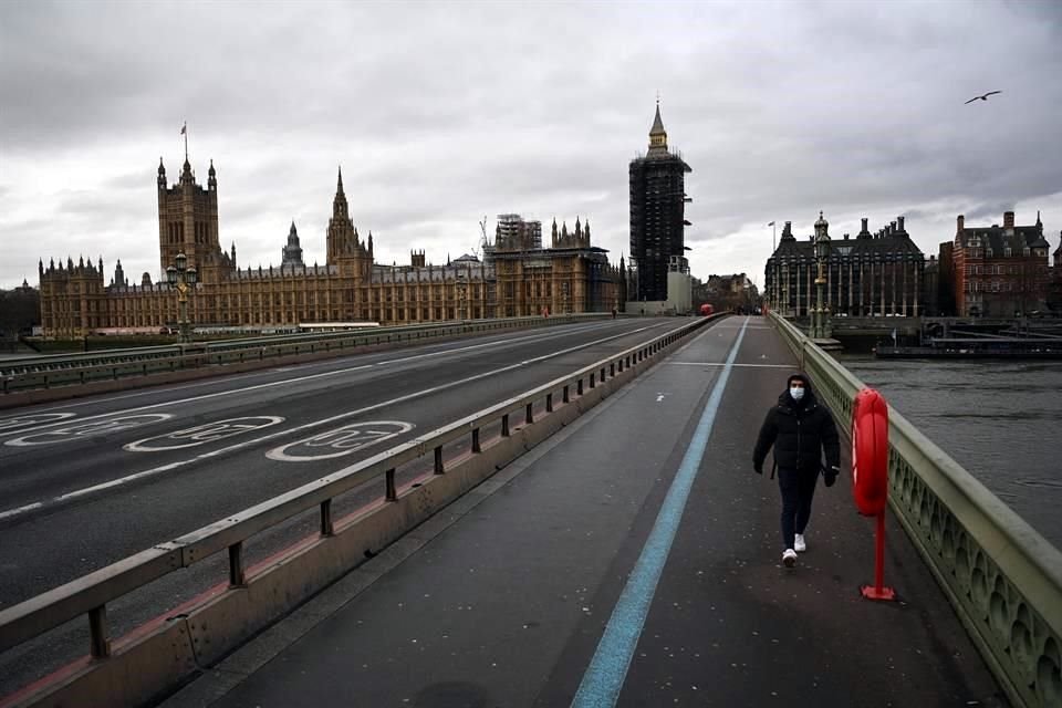 Un hombre con mascarilla camina por el puente de Westminster este martes, al inicio del confinamiento nacional en Inglaterra.