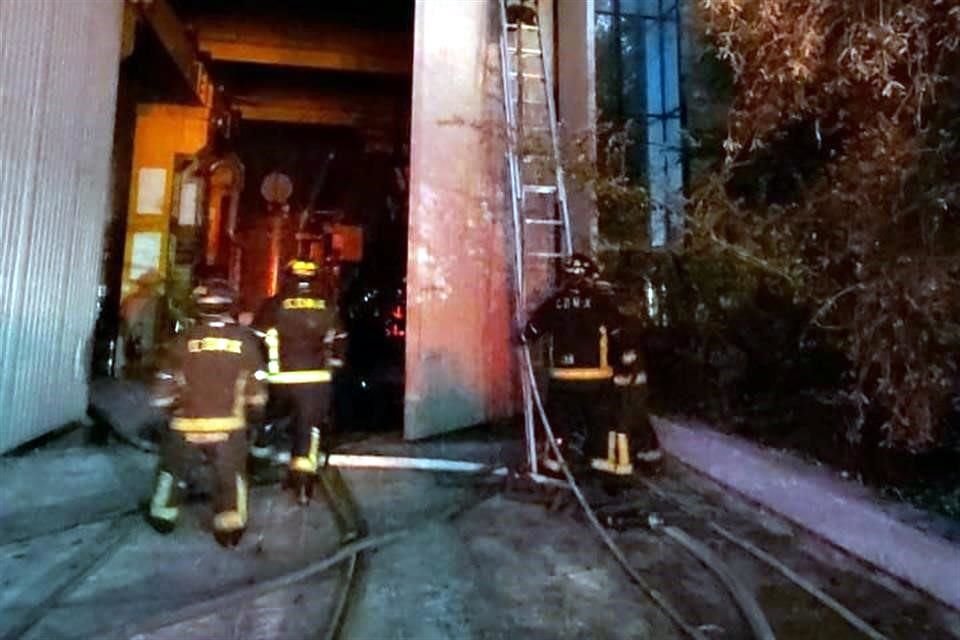 Bomberos laboran en el sitio para sofocar el fuego.