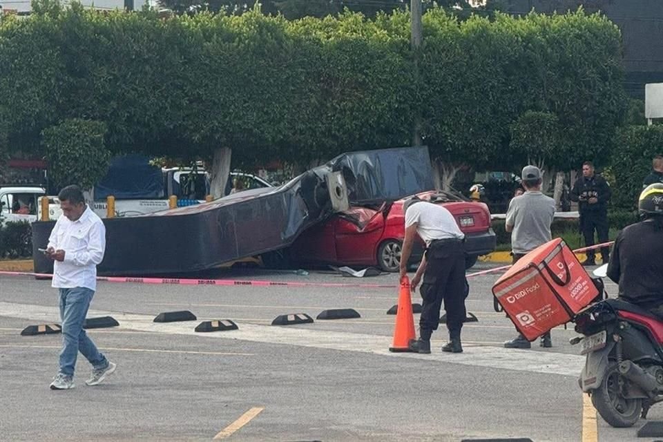 Un auto fue aplastado por el anuncio espectacular de una tienda, en un estacionamiento ubicado en Coacalco.