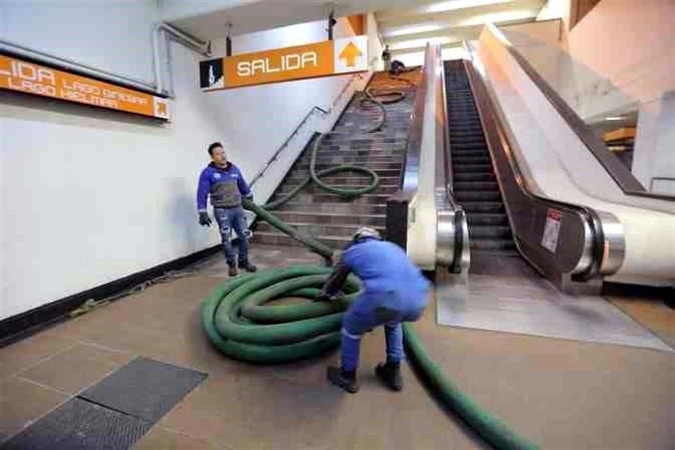 Pasada la medianoche, los trabajadores limpian la basura y suciedad en un hoyo que recibe agua de lluvia y del drenaje.