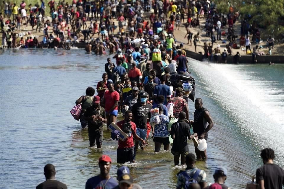 Las personas cruzan con el agua a las rodillas.