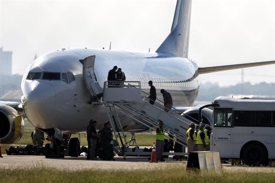 Migrantes haitianos abordan un avión en San Antonio.