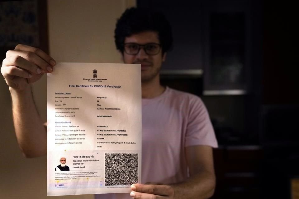 Un hombre en India muestra su certificado de vacunación.