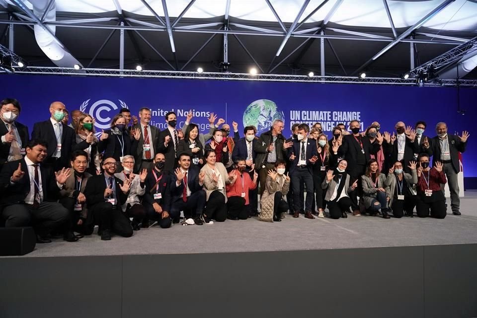 Delegados de la COP26 se toman una fotografía tras horas de negociaciones.