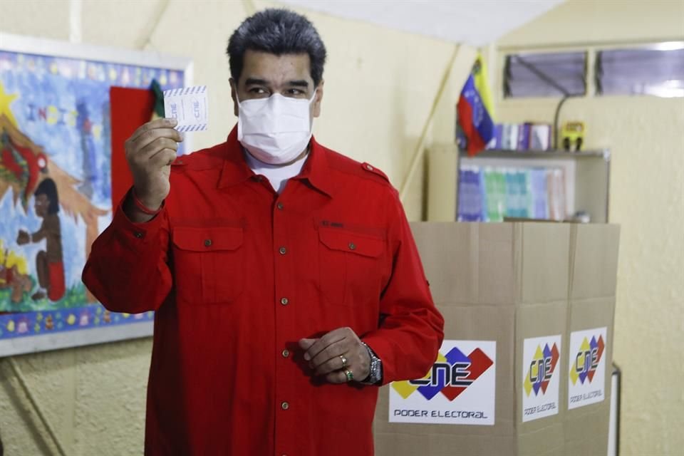 El Presidente de Venezuela, acompañado por su nieta, emite su voto en las elecciones regionales del país este domingo.