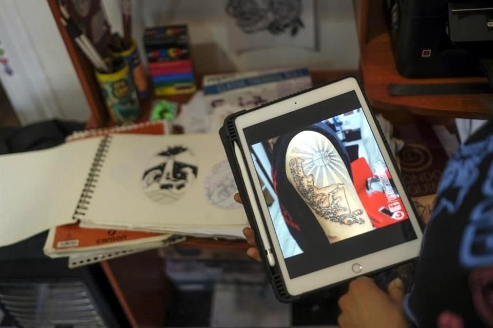 Góngora muestra una foto de uno de los tatuajes que hizo en el brazo del Presidente electo de Chile, Gabriel Boric.
