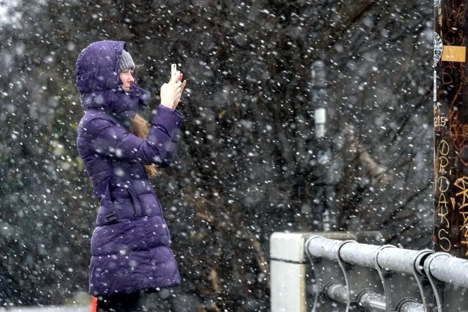 Una mujer en Atlanta toma una foto en medio de la nevada.