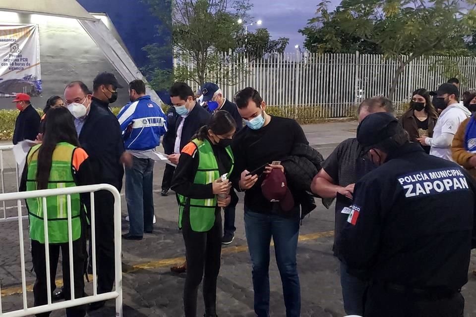 Los aficionados muestran el certificado de vacunación antes de ingresar al Estadio Panamericano.