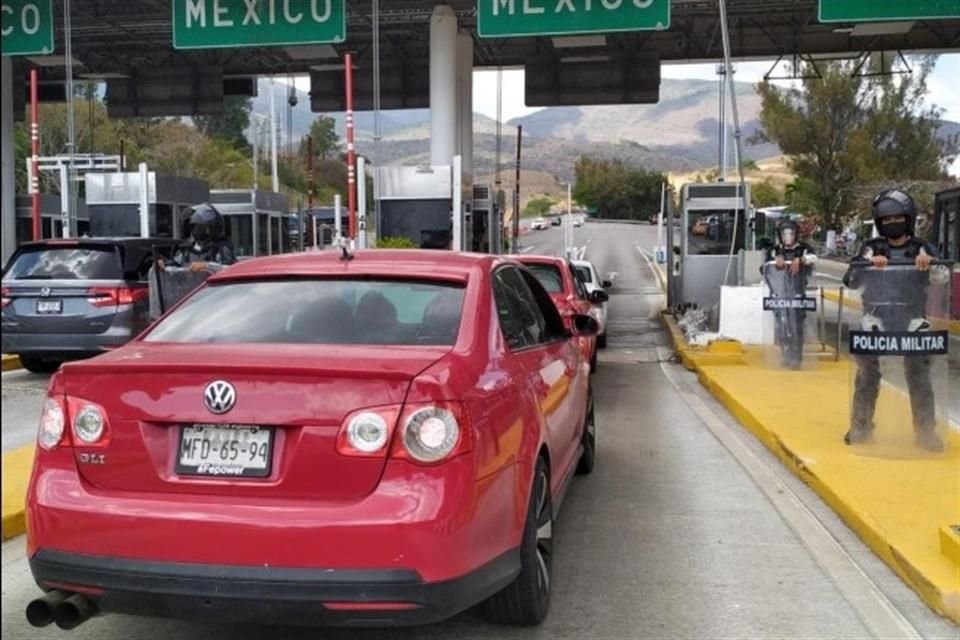 Agentes de la Guardia Nacional y la Policía Estatal mantienen un cerco en la caseta de Palo Blanco de la Autopista del Sol.