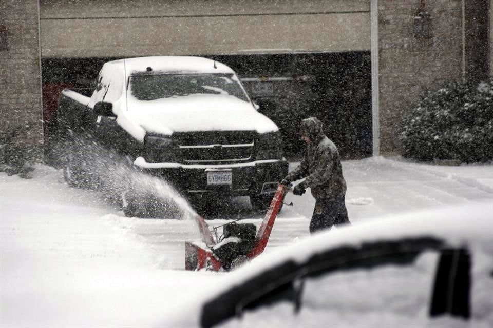 Un hombre en el condado de  St. Charles, Misuri, limpia la calle de la nieve.