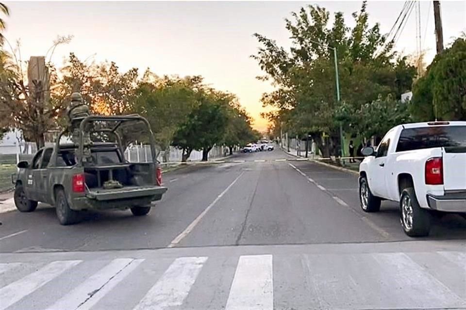 Elementos del Ejército de la Fiscalía estatal acordonaron la calle frente a la Universidad de Colima en donde fueron localizados dos cadáveres en un auto.