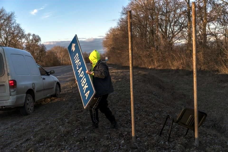 Un ucraniano en Kalynivka, Ucrania, quita señales de tránsito para confundir al Ejército ruso.