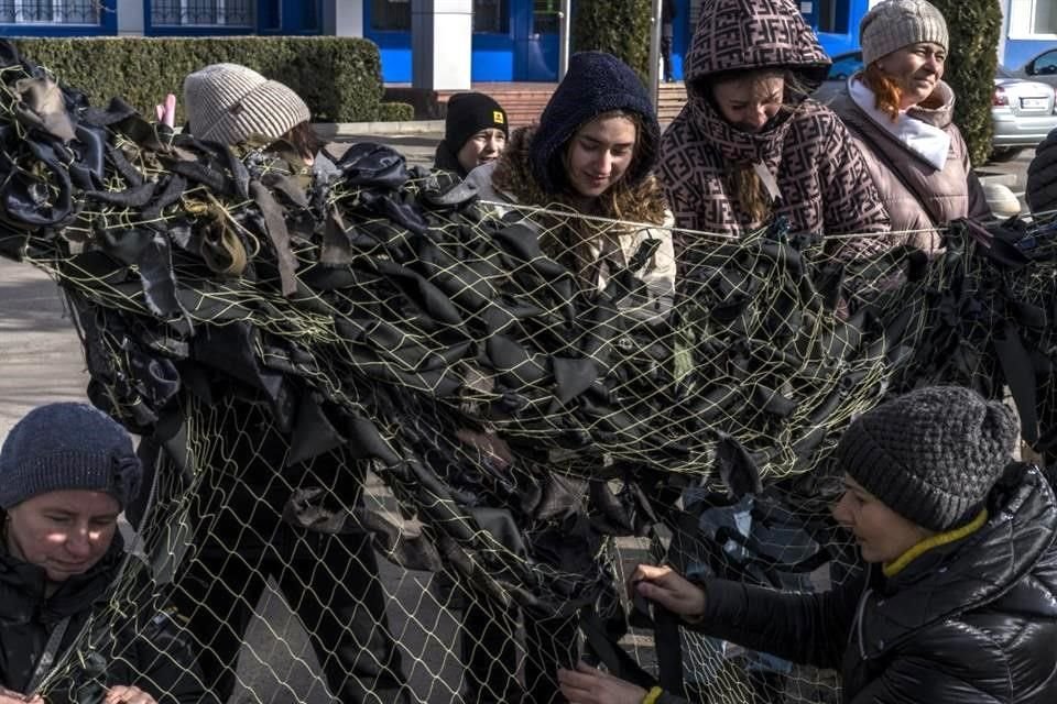 Voluntarios tejen una red de camuflaje en Kalynivka.